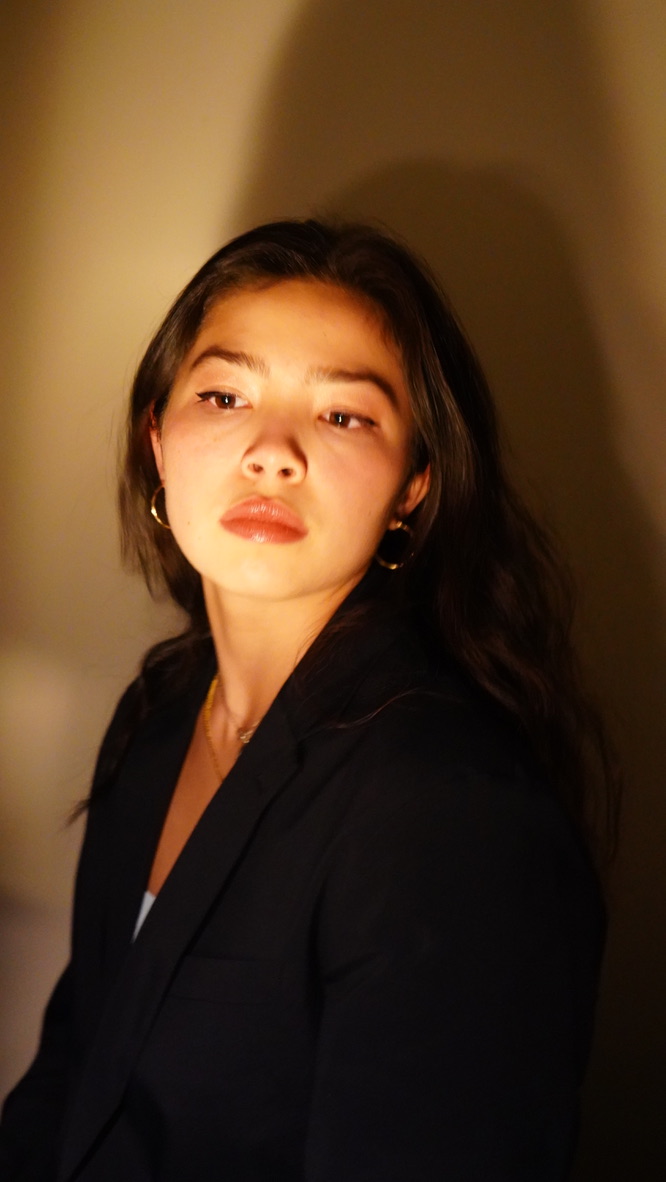 Photo of me looking off to the side with warm lighting creating a shadow behind me